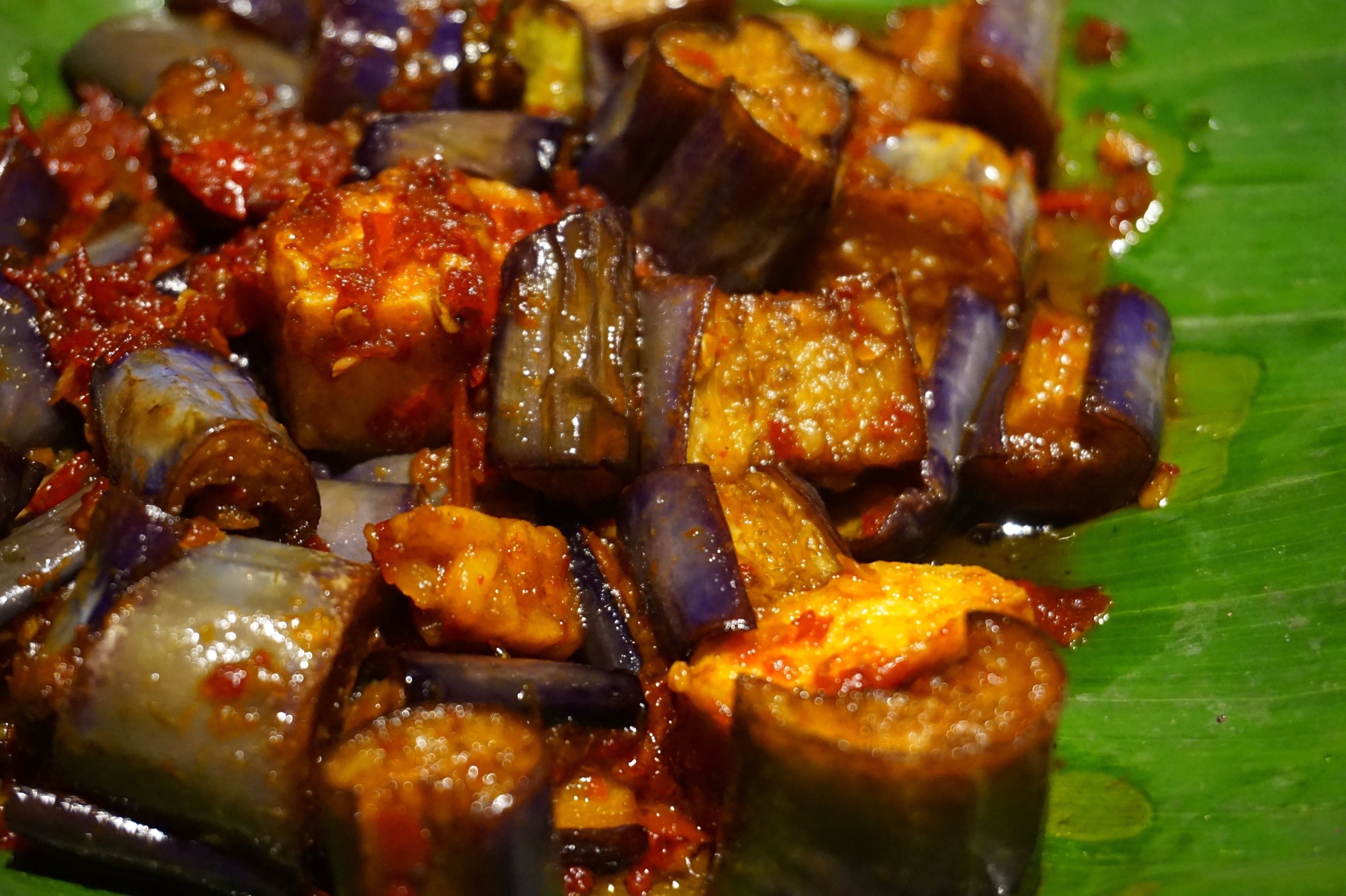 A close-up of a dish with eggplant and tomato sauce.