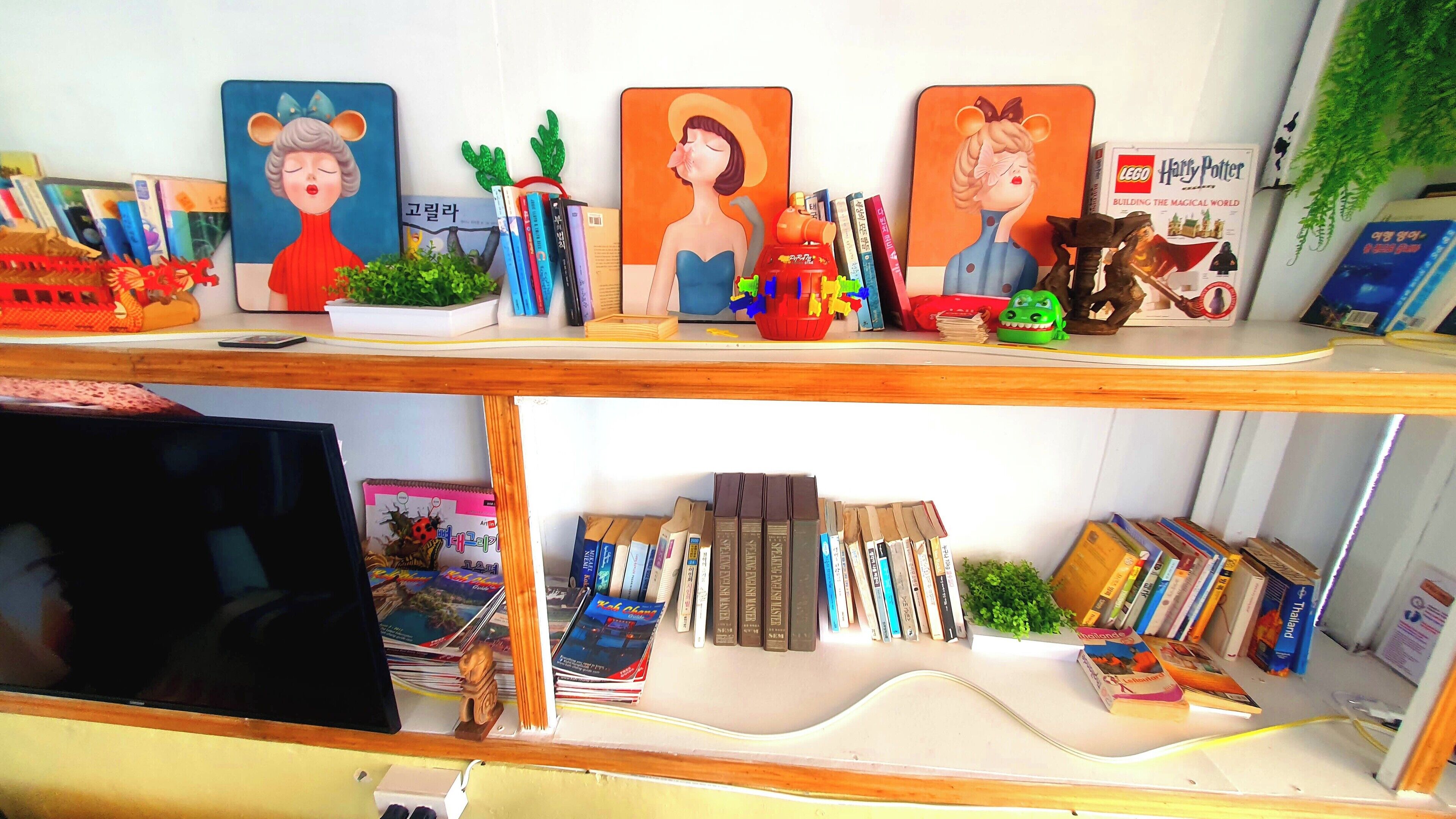 Una estantería con libros, objetos decorativos y una planta pequeña.