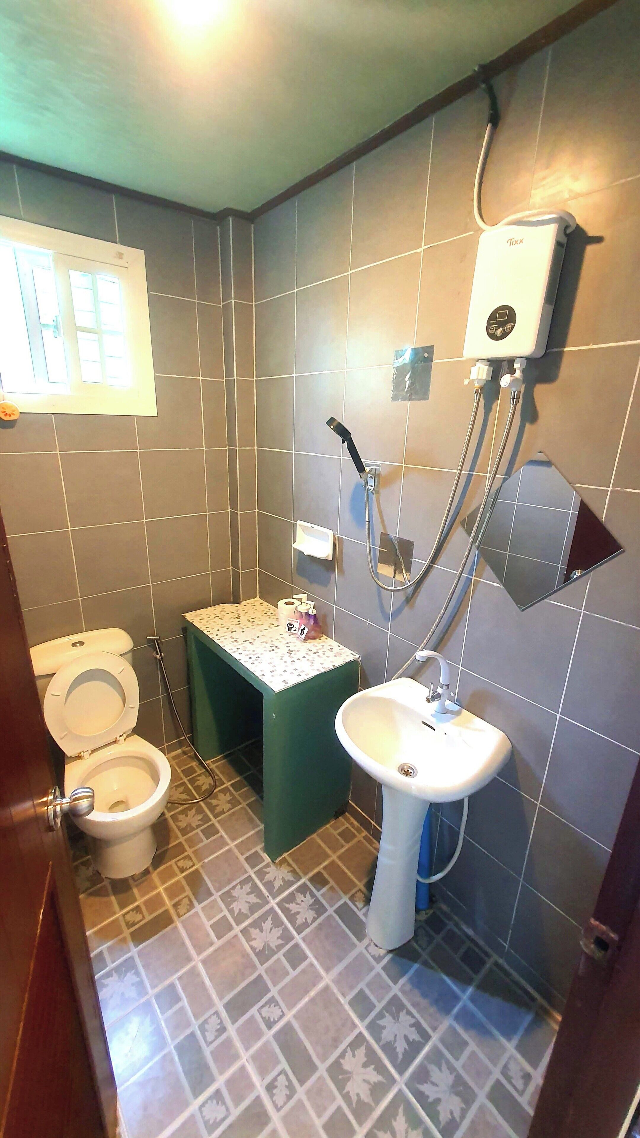 A small bathroom with a toilet, sink, and shower.