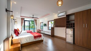 A modern bedroom with a bed, built-in wardrobe, and a ceiling fan. - Hung Do Beach Homestay (Da Nang)