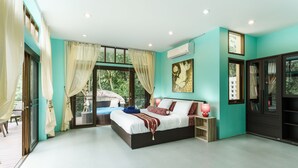 Un dormitorio moderno con una cama grande, vistas a zonas verdes y una puerta corredera a un balcón.