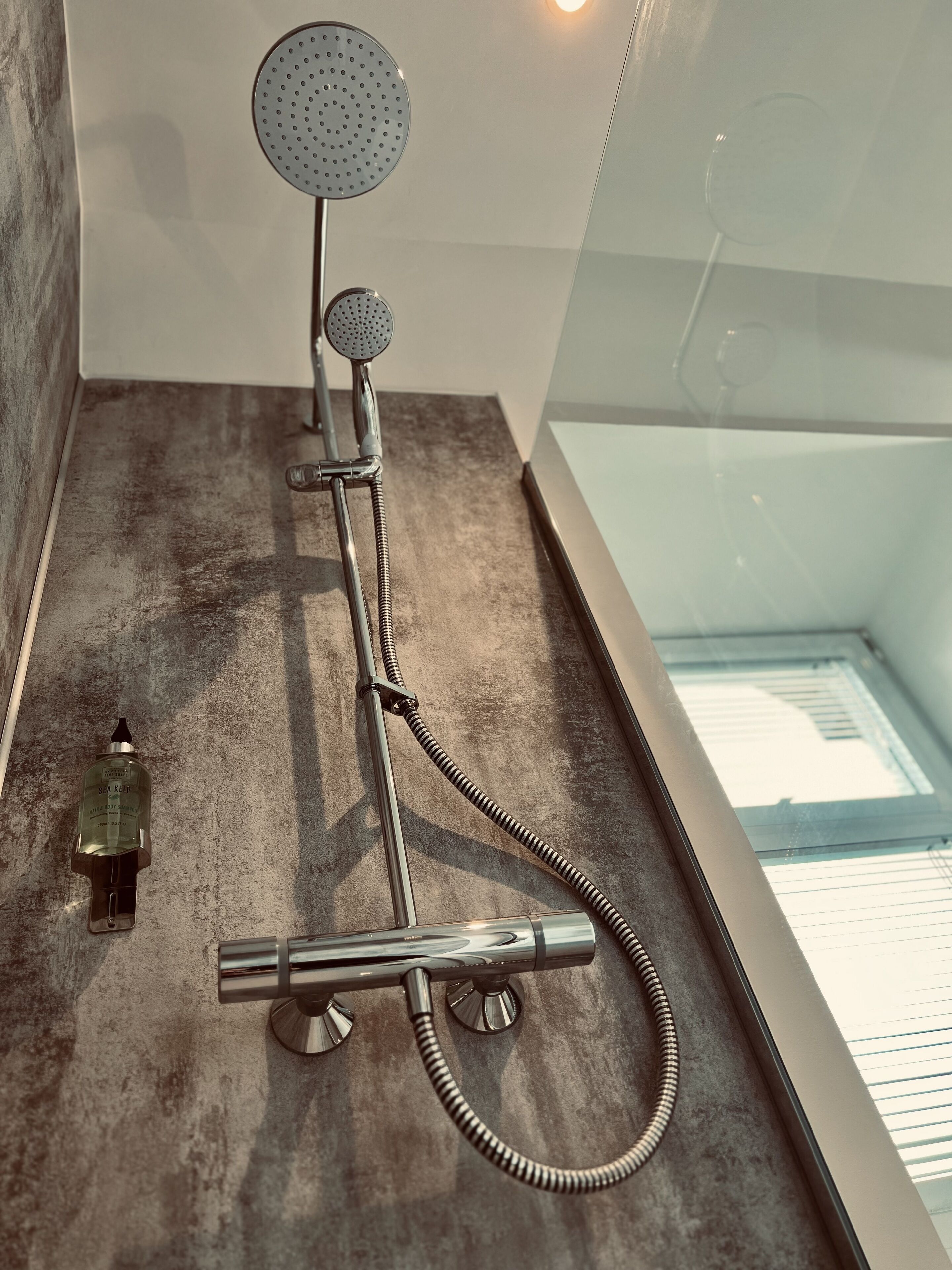 Eine Dusche mit Handbrause und Massagegerät.