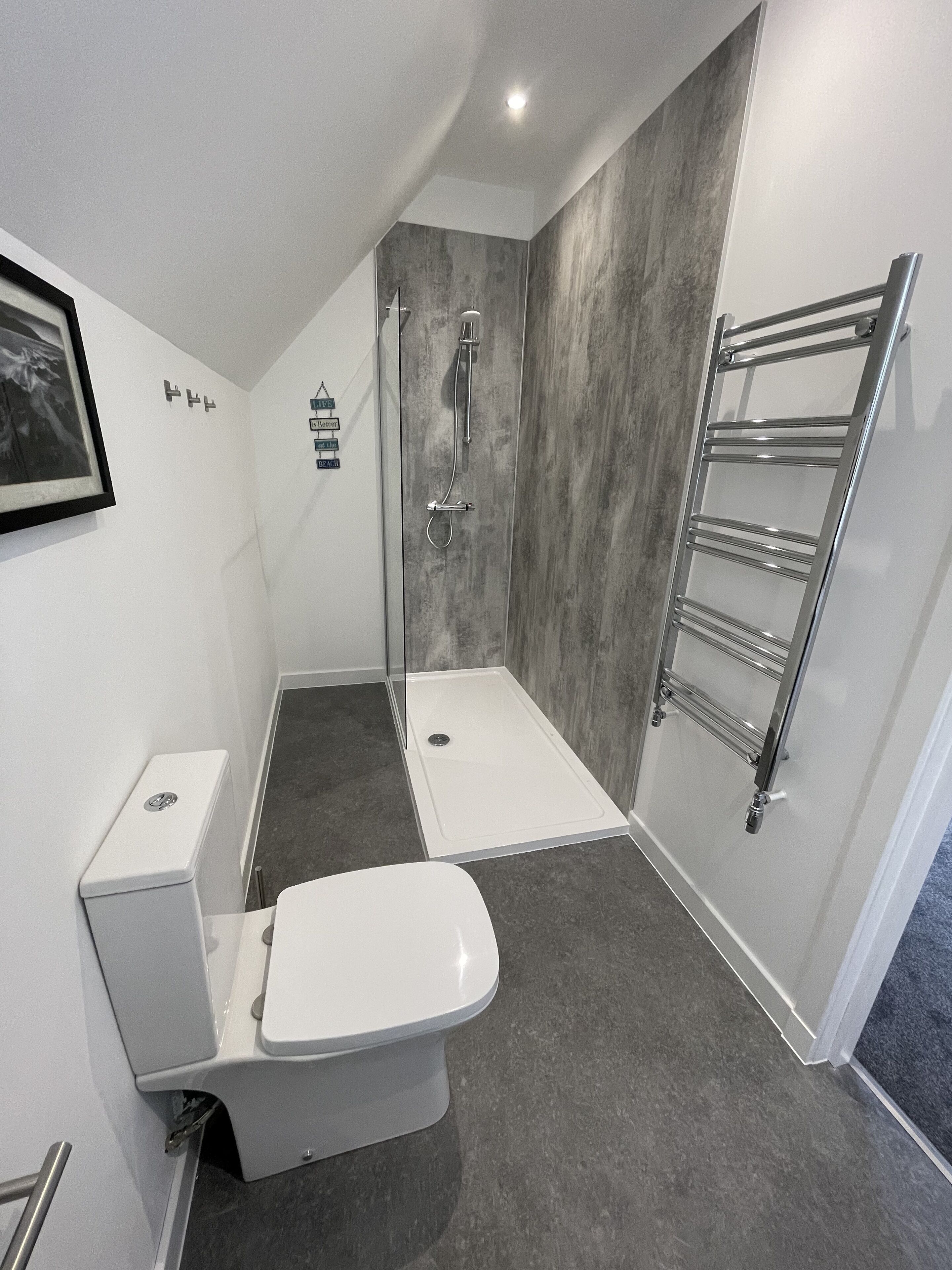 Ein modernes Badezimmer mit Dusche, Toilette und Handtuchhalter.