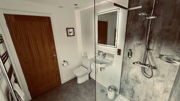 A modern bathroom with a toilet, sink, and shower.