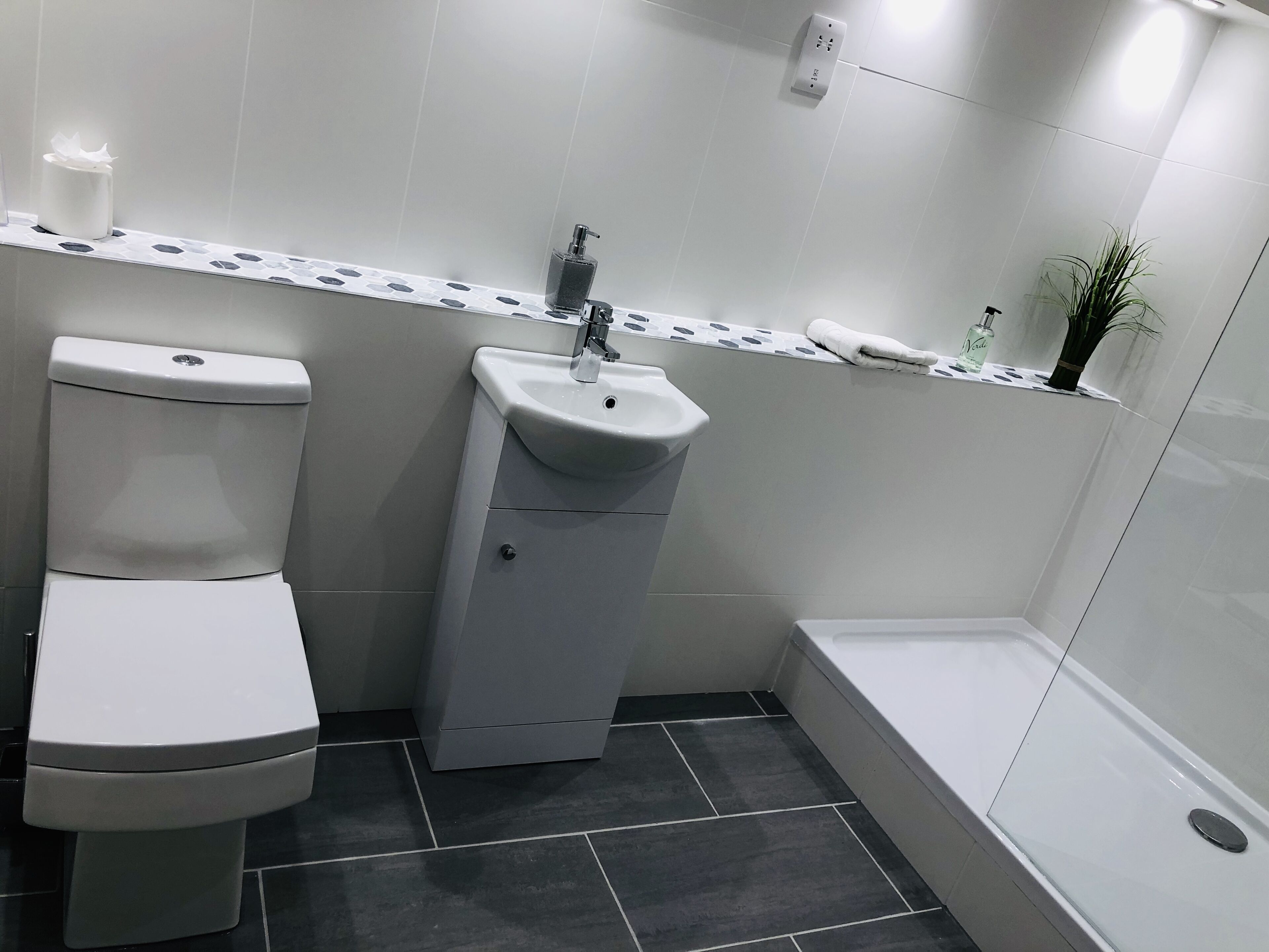 A bathroom with a toilet, sink, and bathtub.