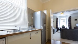 A modern kitchen with a stainless steel refrigerator, a built-in oven, and a sink. - Apartment 32 (York)