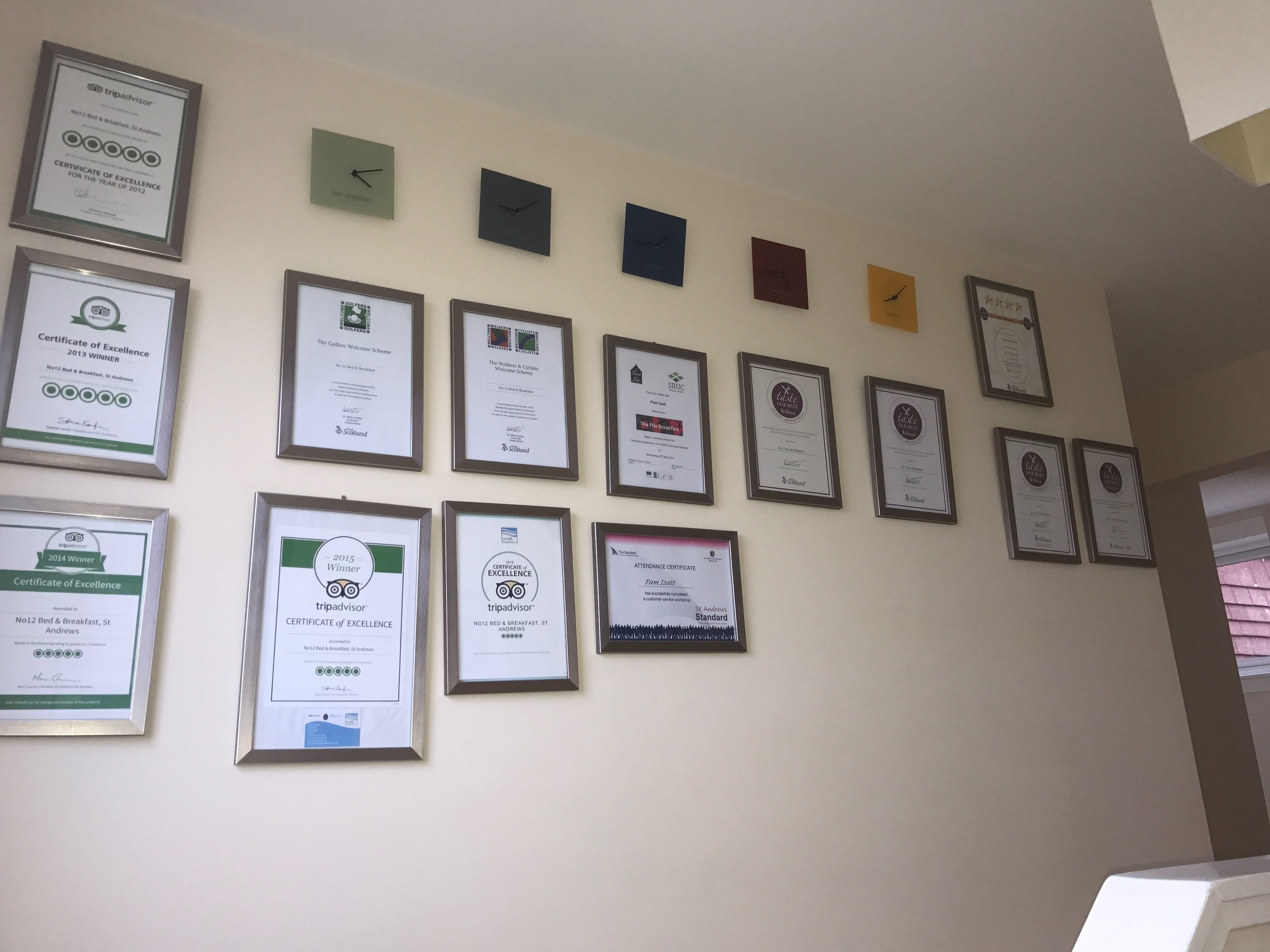 Un mur orné de nombreux certificats et trophées encadrés.