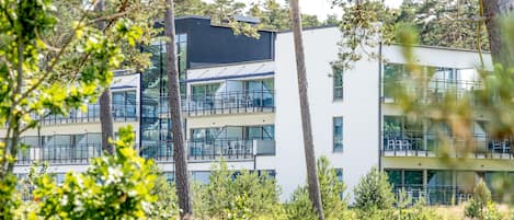 A modern building with multiple floors, large windows, and balconies.