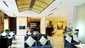 A hotel lobby with seating areas, a reception desk, and a large window. - Sovereign Hotel KunShan (Suzhou)