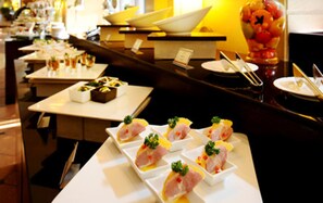 A buffet setup with various dishes and a fruit display. - Sovereign Hotel KunShan (Suzhou)