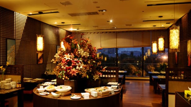 A restaurant with a central round table displaying various dishes, surrounded by seating. - Sovereign Hotel KunShan (Suzhou)