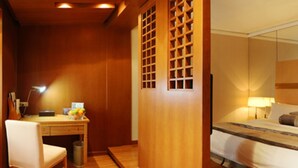 A hotel room with a wooden desk, chair, and a bed with a headboard. - Sovereign Hotel KunShan (Suzhou)