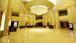 A spacious lobby with a large chandelier, high ceilings, and a polished floor. - Sovereign Hotel KunShan (Suzhou)