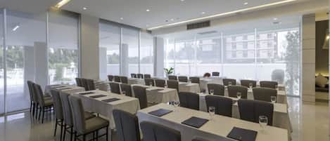 A modern conference room with long tables and chairs, large windows, and a clean, minimalist design.