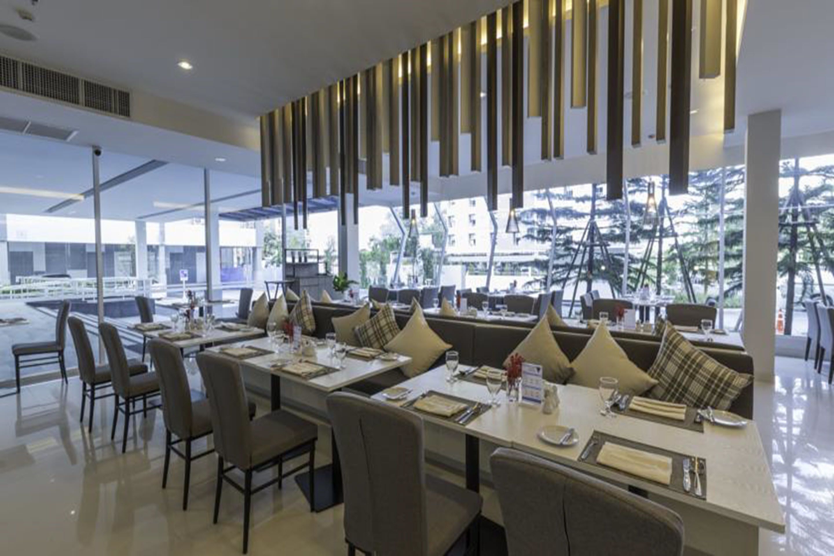 A modern restaurant with high tables and comfortable seating, large windows offering a view of the cityscape.
