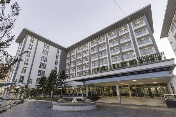 A modern hotel with a central courtyard, multiple balconies, and a well-lit entrance. - Kantary Hotel & Serviced Apartments Amata, Bangpakong (Chonburi)