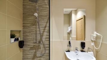 Habitación con 1 cama matrimonial o 2 individuales | Baño | Regadera, amenidades de baño gratuitas, secadora de cabello, pantuflas