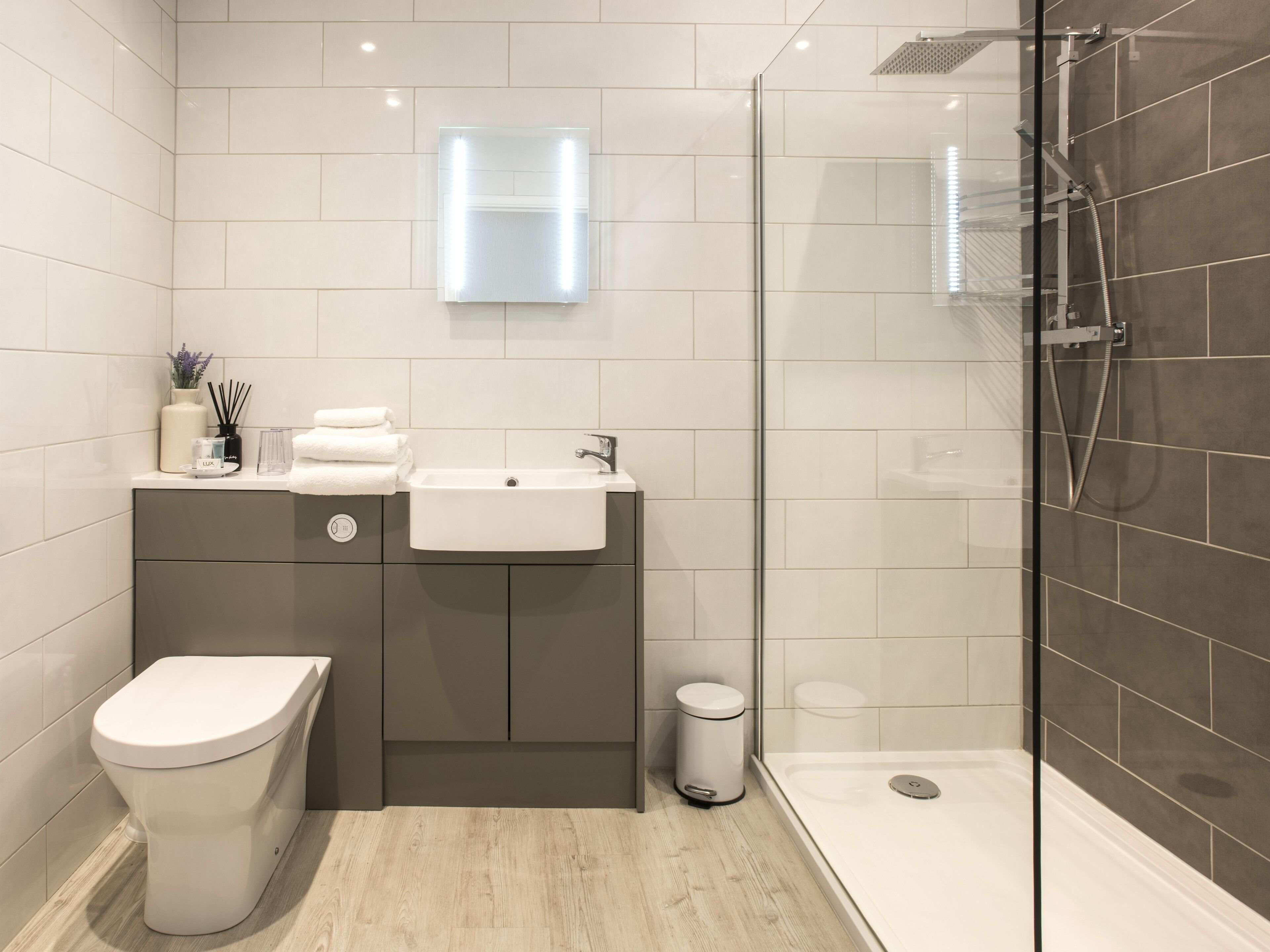 Une salle de bain moderne équipée de toilettes, d’un lavabo et d’une douche.