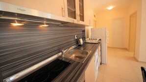 Eine Küche mit schwarz-weiß gestreifter Arbeitsplatte, einem Edelstahlspülbecken und einem eingebauten Backofen.