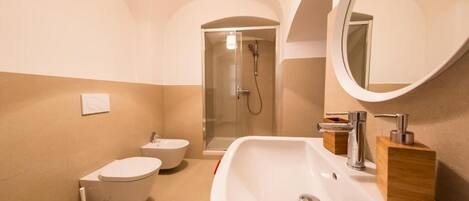 A modern bathroom with a toilet, bidet, and sink.
