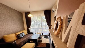 Una sala moderna con un sofá, un reposapiés y una mesa de comedor.
