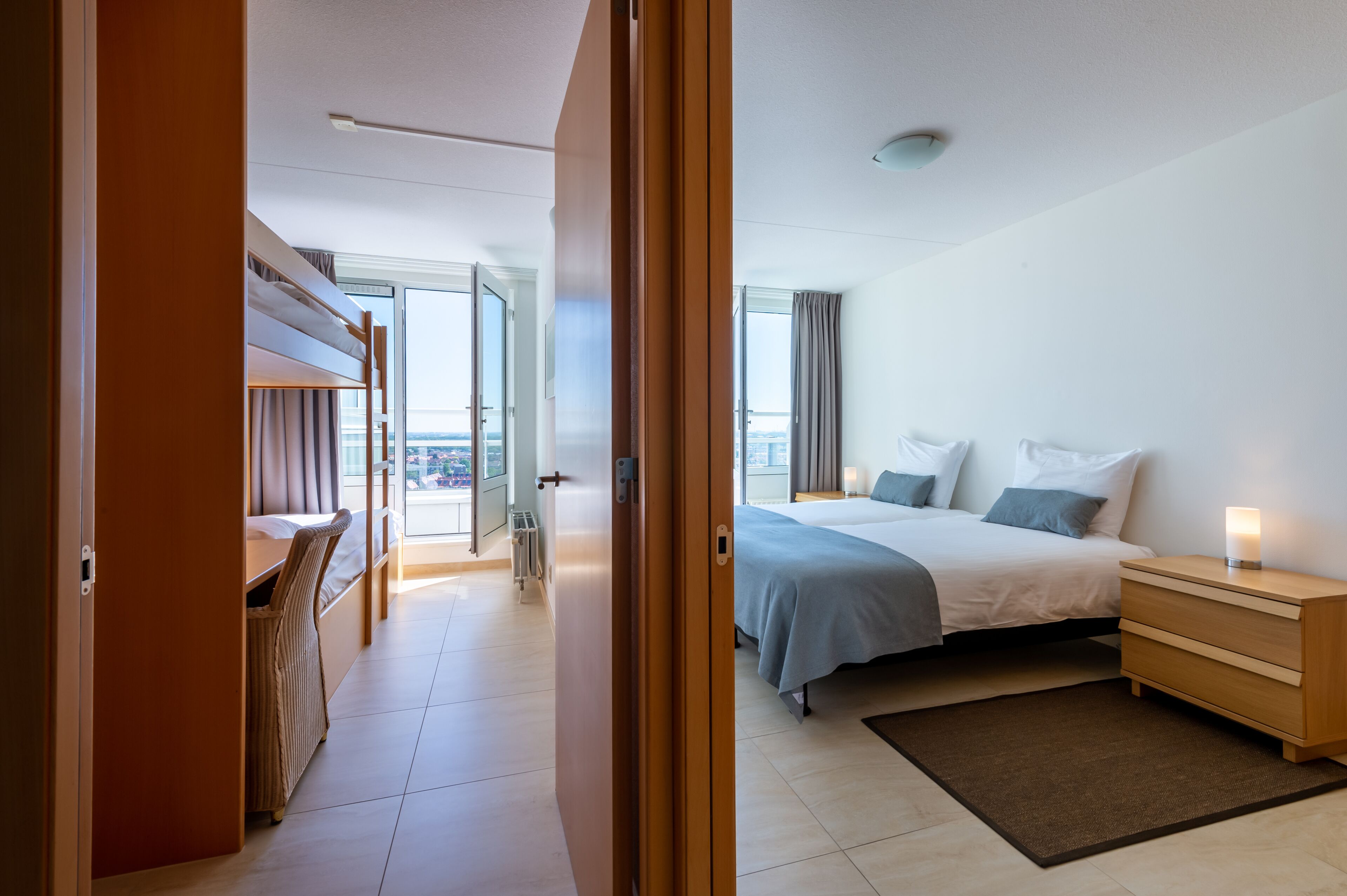 Een hotelkamer met een bed, nachtkastje en uitzicht op de stad.