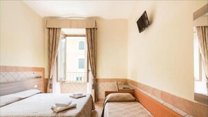 A hotel room with two beds, a TV mounted on the wall, and a balcony with curtains. - Alex Romano (Rome)