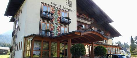 Ein zweistöckiges Gebäude mit einem Schild, auf dem „Hotel Berghof“ steht.