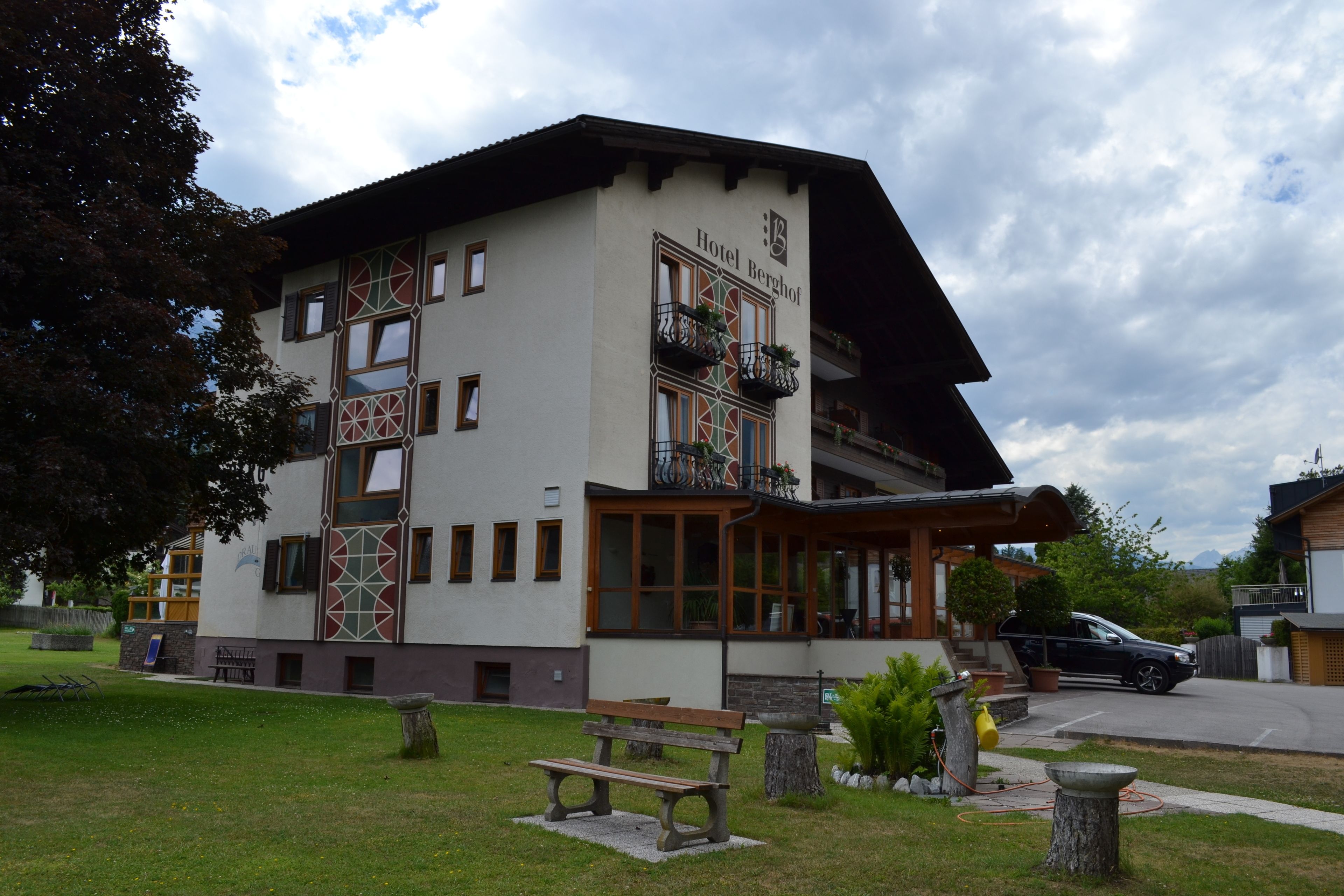 A two-story building with a balcony and a sign that reads "Hotel Berghof".