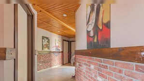 A hallway with a wooden ceiling, a brick wall, and a tiled floor. - Sun Anatolia Otel (Antalya)