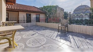 A courtyard with a tiled floor, a wooden pergola, and a view of a mosque with a dome. - Sun Anatolia Otel (Antalya)