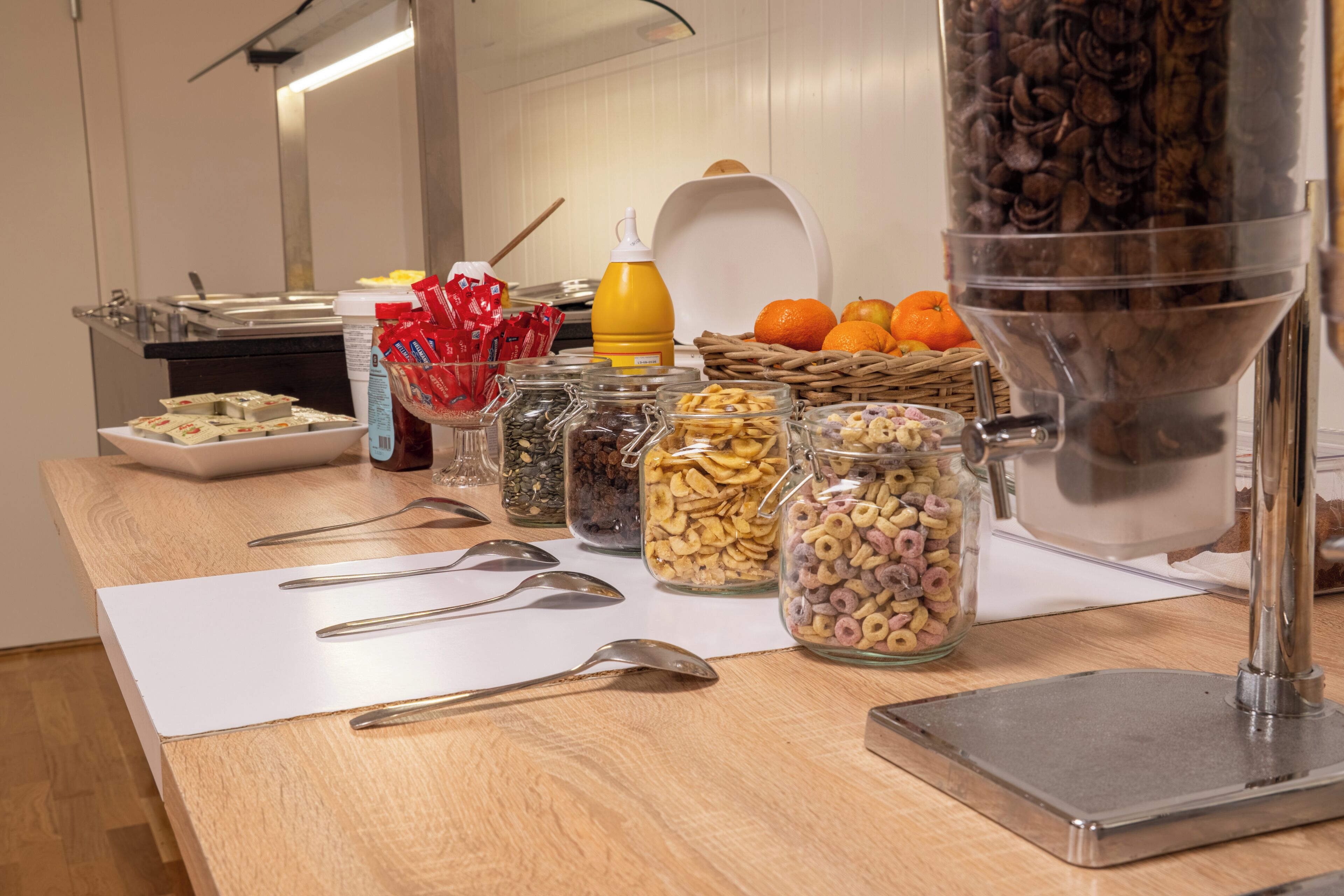 A buffet table with various food items and utensils.