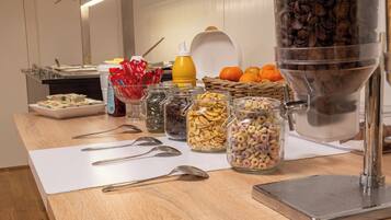 Una mesa de bufé con diversos alimentos y utensilios.