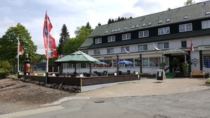 Een hotel met terras, een vlag en een bord met de tekst 'Hotel Engel'.