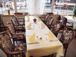 A long dining table set for a meal with numbered place settings, surrounded by patterned chairs.