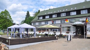 Een hotel met terras, een overdekt gedeelte en een bord dat aangeeft dat het een hotel is.