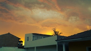 A building with a flat roof and a visible power line. - Casa Nunes (Florianópolis)
