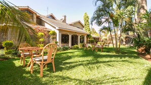Una casa con patio amoblado y un césped bien cuidado.