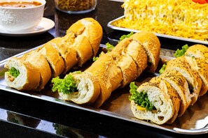 A tray with three sandwiches on a black countertop.