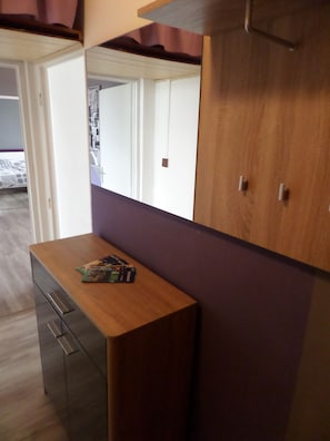 A room with a wooden desk, a mirror, and a wardrobe.