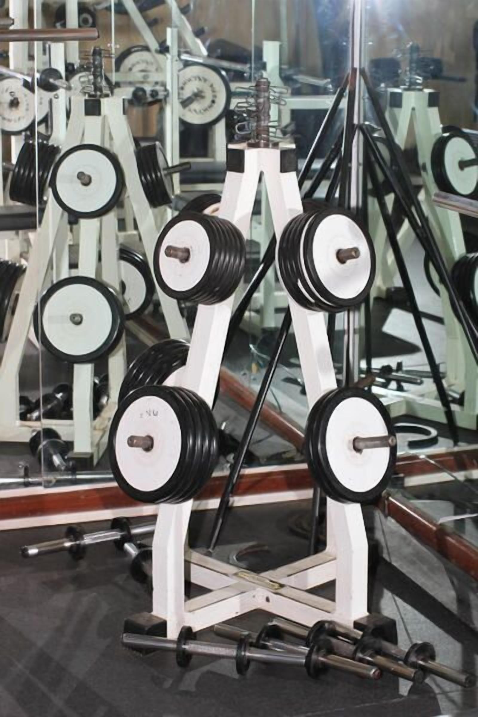 A gym with weightlifting equipment, including dumbbells and barbells.