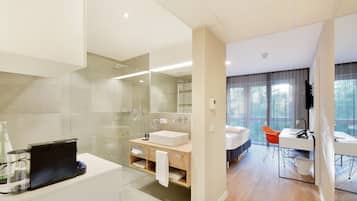 A modern bathroom with a glass shower enclosure, a white sink, and a wooden vanity.