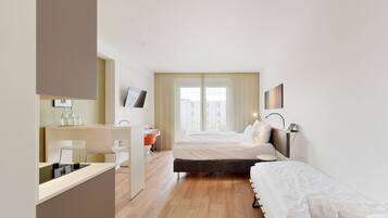 Quarto de hotel moderno com cama, mesa de cabeceira e escrivaninha com cadeira.