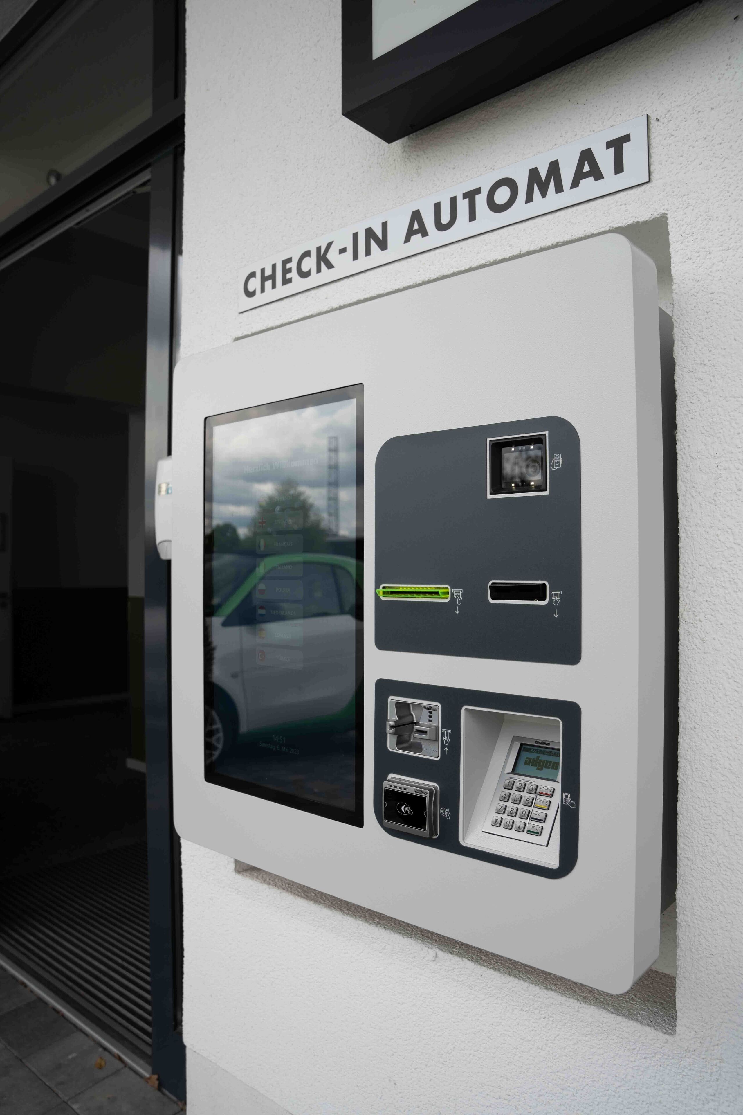 A check-in automat with a screen, card reader, and keypad.