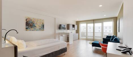 Una habitación de hotel moderna con cama, escritorio y zona de estar.