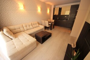 Relax in this stylish living room with a comfortable sofa, dining area, and large mirror.