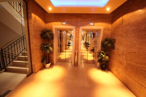Stunning hallway with polished floors, potted plants, and a grand staircase.
