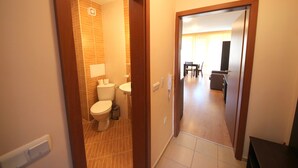 Une salle de bain d’hôtel équipée de toilettes, d’un lavabo et d’une poubelle.