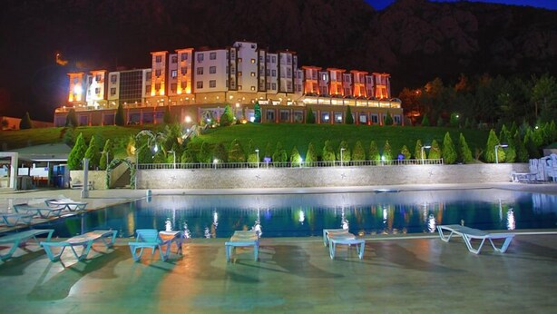 Una piscina al aire libre, sombrillas, sillones reclinables de piscina