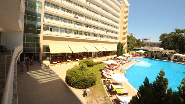 Ein Hotel mit Schwimmbad, Außenbereich und einem mehrstöckigen Gebäude.